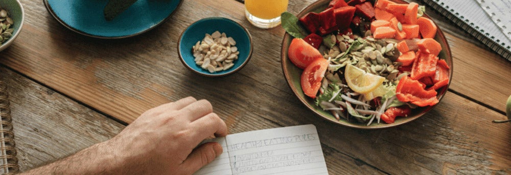 Persona haciendo un listado de alimentos saludables y porciones adecuadas