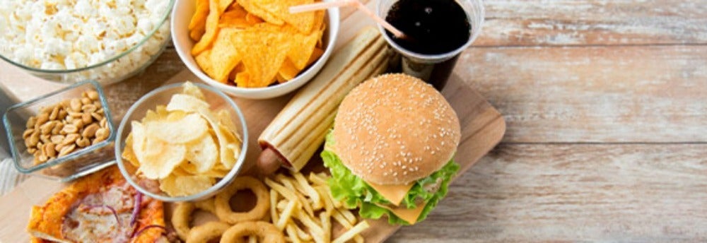 Comidas rápidas como hamburguesa, salchichas y papas fritas que tienen grasas trans