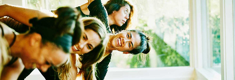 Mujeres ríen en una clase de yoga para mantener mente y cuerpo sanos