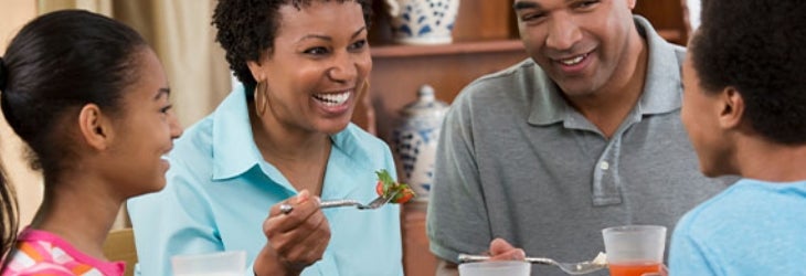 Familia de cuatro miembros disfruta de una comida balanceada para la noche