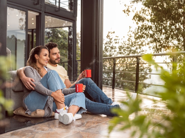 Pareja tomando un café NESCAFÉ® en un balcón