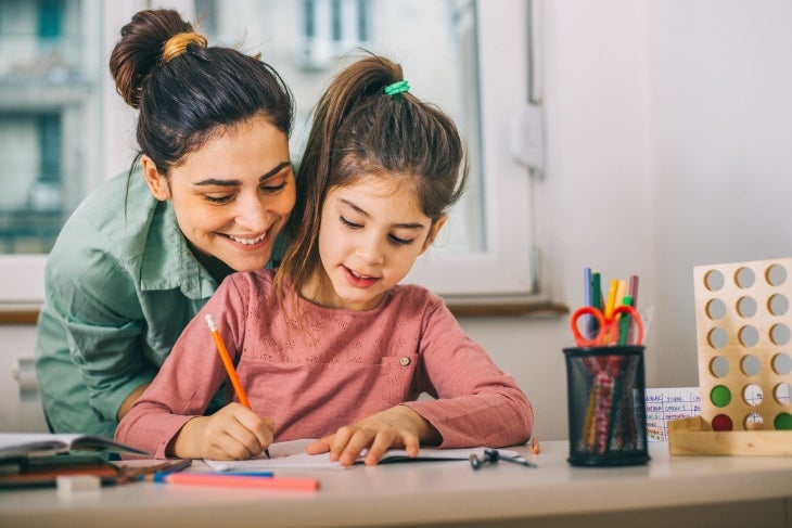 Mamá ayudando a estudiar a su hija