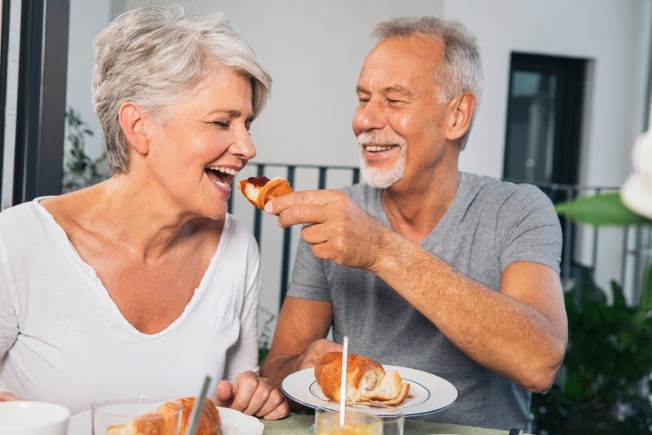 Pareja comiendo un snack y sonriendo