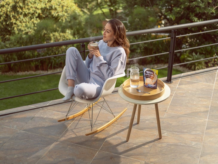 Mujer tomando NESCAFÉ® después de terminar su jornada laboral