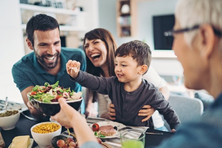 Compartir comidas en familia promueve la comunicación Familia sonriendo mientras come en familia