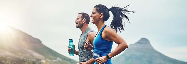 Hombre y mujer realizan ejercicio físico promovido por las pausas activas