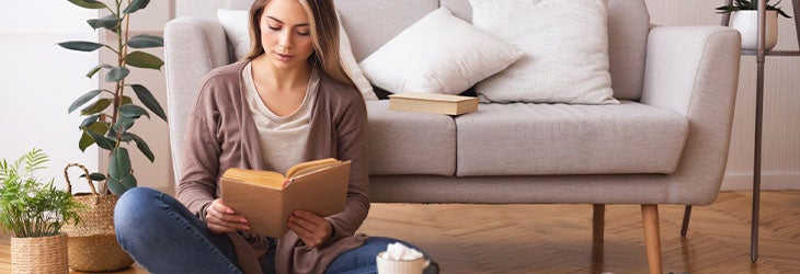 Mujer lee un libro y consulta sobre educación emocional 