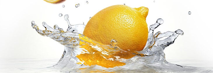 Fuentes para hidratarte: una fruta como el limón que cae al agua