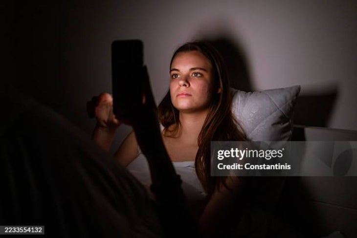 Mujer mirando el celular antes de dormir