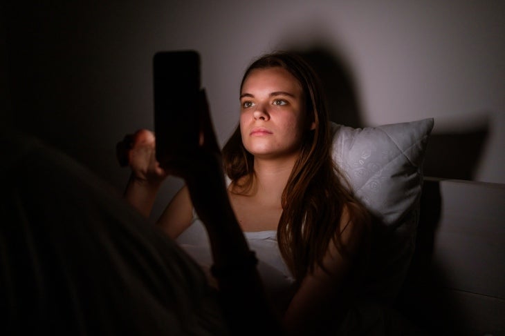 Mujer mirando el celular antes de dormir