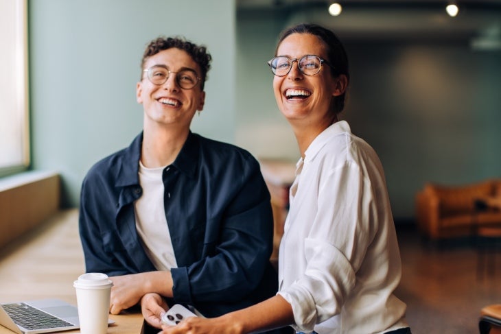 Compañeros de trabajo sonriendo antes de iniciar el trabajo