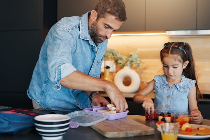 Papá empacando la lonchera saludable con su hija