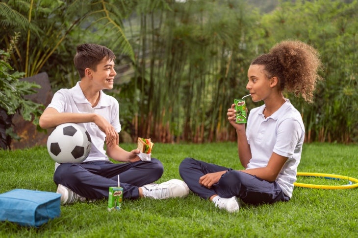 Niños tomando onces en el colegio tomando MILO® Cajita