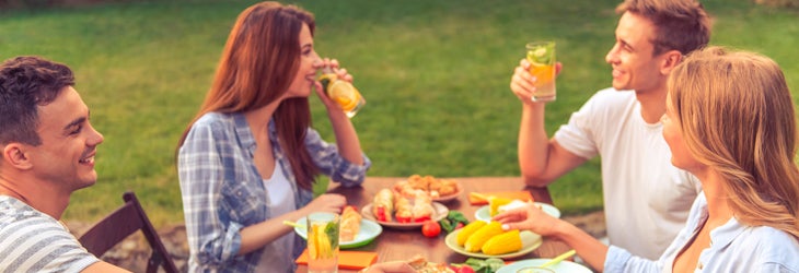 Dos parejas disfrutan un almuerzo con proteína vegetal al aire libre