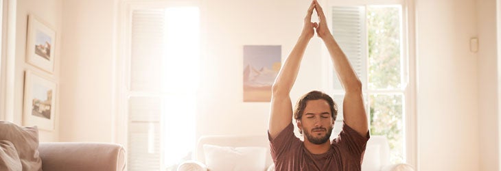 Hombre practica yoga como actividad física y pausa en pro de su inteligencia emocional