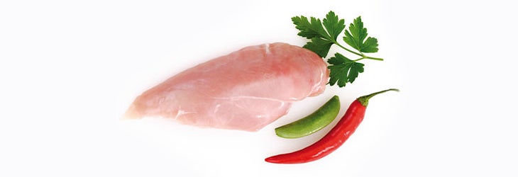 Filete de pechuga de pollo deshuesada acompañado de perejil y ají