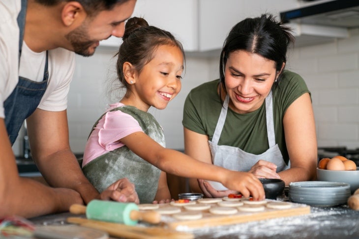 Cocinar en familia puede ser divertido en el receso escolar Familia cocinando juntos en el receso escolar