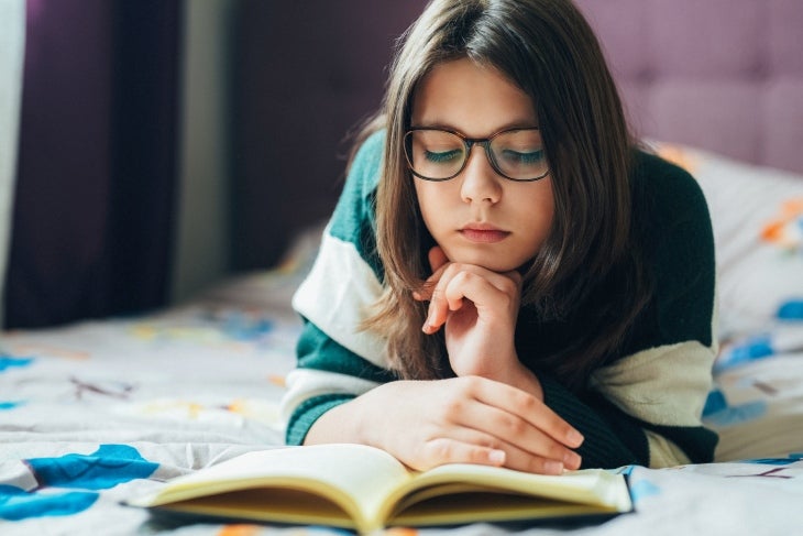 Leer lo que te gusta es una opción en el receso escolar Niña leyendo en el tiempo de receso escolar