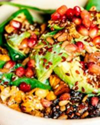 Un plato con lentejas crocantes, aguacate, granada y calabaza. 