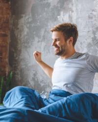Hombre despertando en su cama porque tiene el hábito de madrugar 
