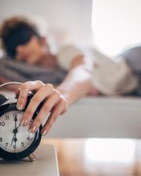 Mujer apagando la alarma para inicia su mañana