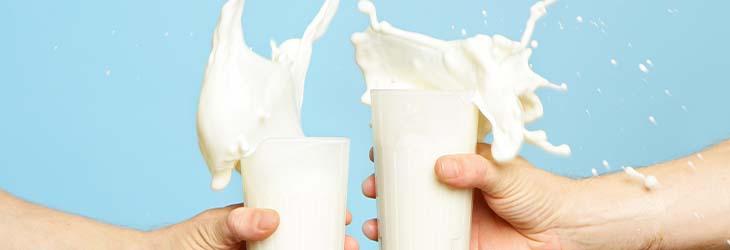 Personas chocan vasos con alimentos lácteos como KLIM® y el Rodeo® que tienen vitamina A