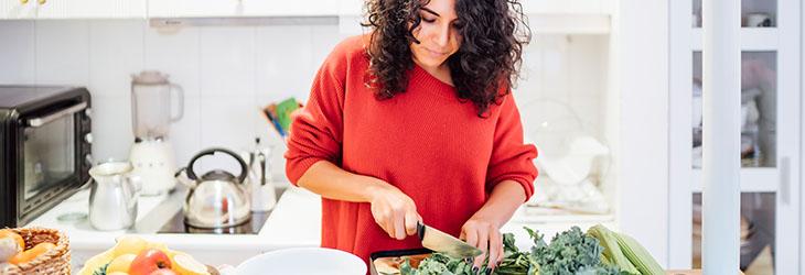 Mujer prepara una ensalada verde para disfrutar de una nutrición vegetariana