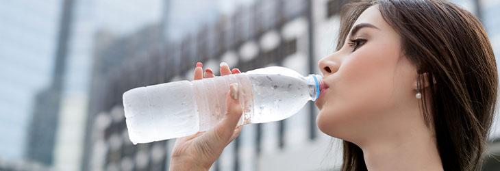 Mujer en periodo de lactancia bebe suficiente agua para mantenerse hidratada