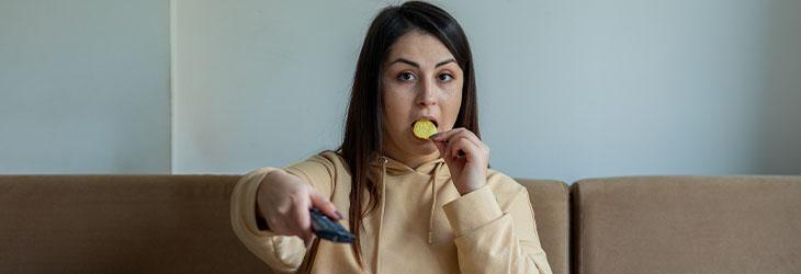 Mujer consumiendo comidas ultraprocesadas que no aportan a los hábitos alimentarios