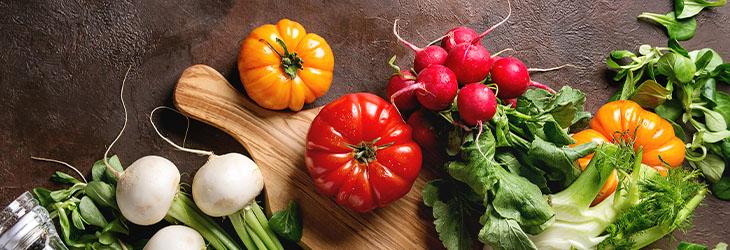 Tipos de vegetales crudos sobre una tabla de picar y listos para ser preparados