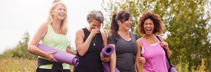 Grupo de amigas camina y sonríe luego de hacer ejercicio para trabajar en wellness