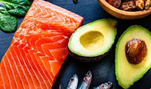 Alimentos fuente de grasas saludables, como aguacate, salmón y frutos secos.