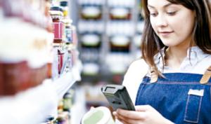 Mujer verifica el valor nutricional de un alimento con un celular en el supermercado