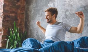 Hombre despertando en su cama porque tiene el hábito de madrugar 