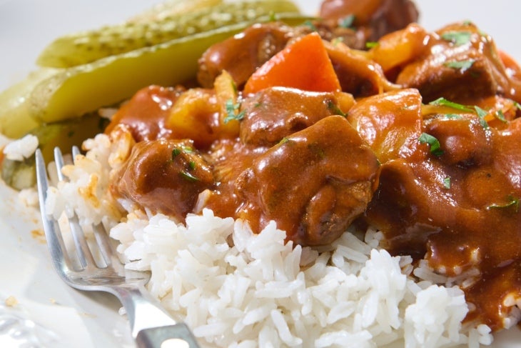 Sudado de carne, típico sabor de Colombia. Plato de sudado de carne con arroz y verduras.