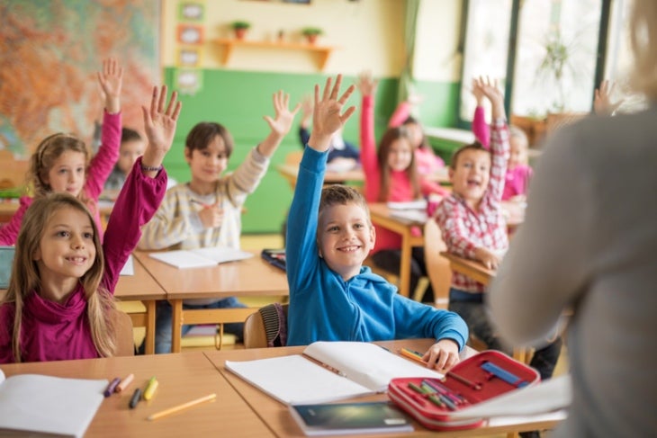 Niños en el colegio participando en clase